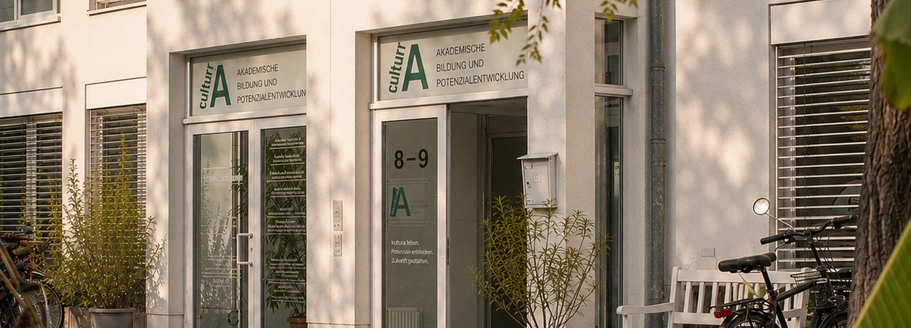 Eingang von cultur|A in Bonn mit Sitzgelegenheit und Pflanzen vor dem Gebäude