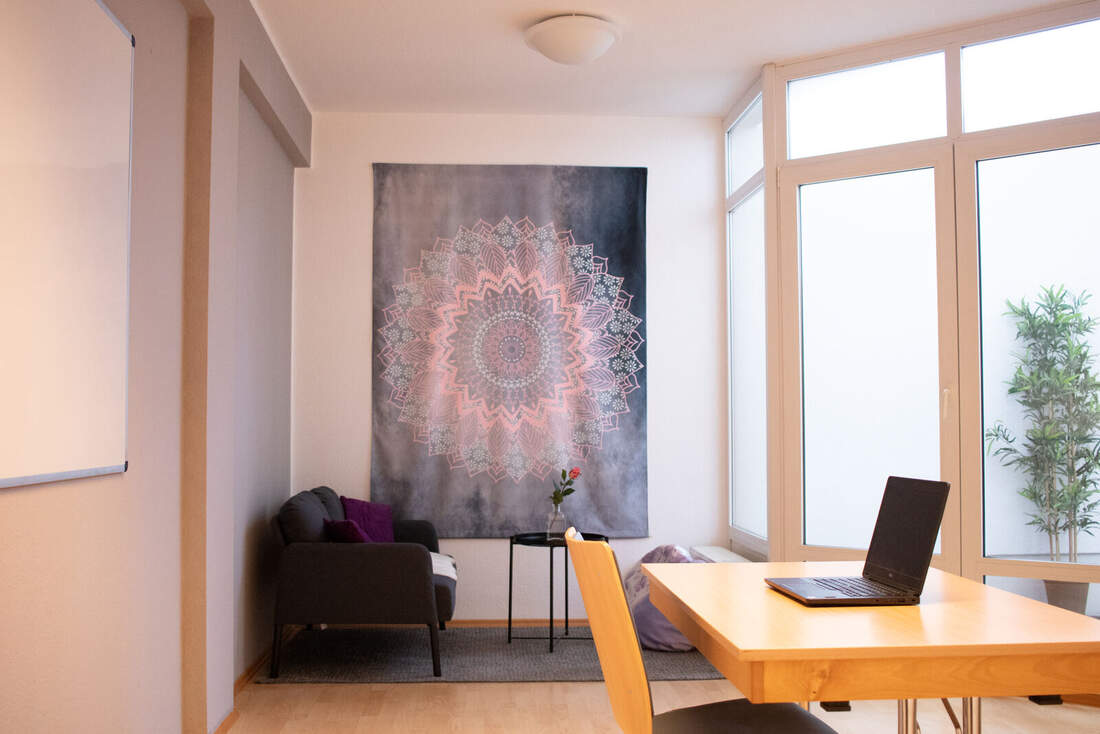 Seminarraum 2: Sitzecke mit Sofa und Schreibtisch mit Laptop